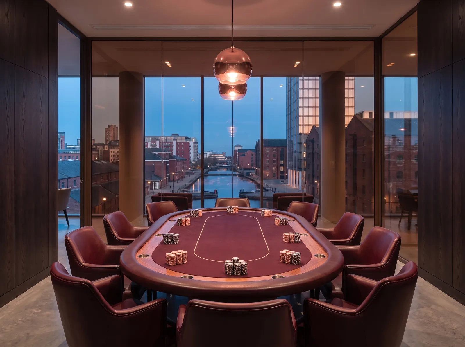 The Rose Room: an oval card table ringed by oxblood leather chairs before a glass wall over the canal